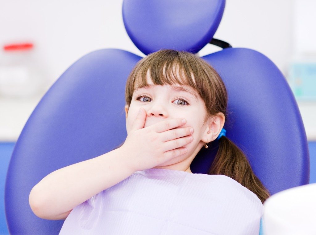 Frightened kid at dentist chair