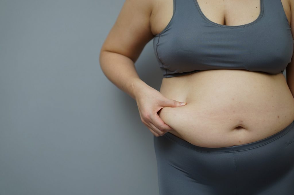 Obese woman pinching her tummy