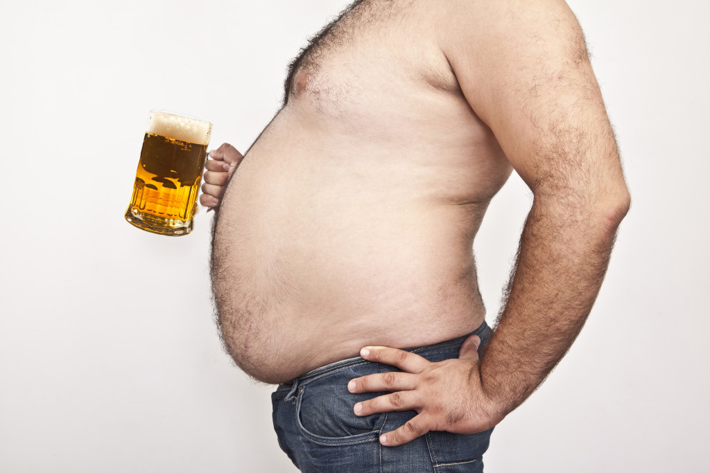 man with large belly fat holding a beer mug