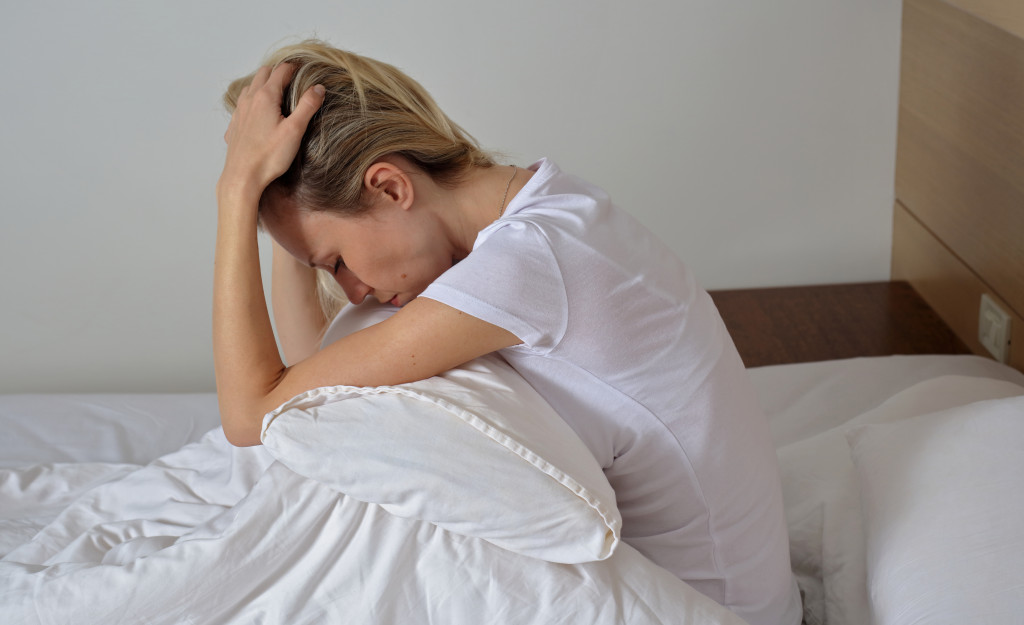 woman clutching her head upon waking up