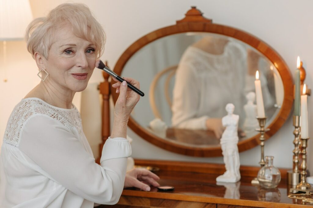 confident old woman doing makeup