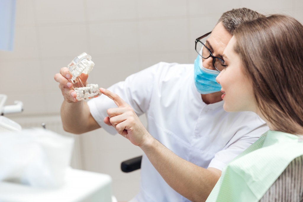 a male dentist discussing the procedure to a female patient