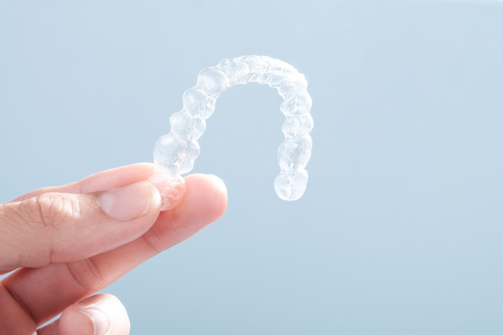 A person holding clear aligners
