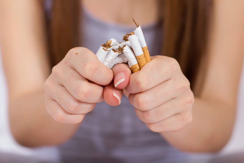 A woman snapping cigarettes in two