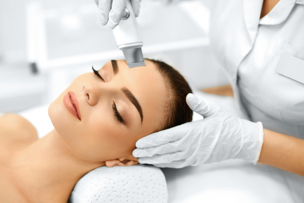 a woman with nurse performing microdermabrasion