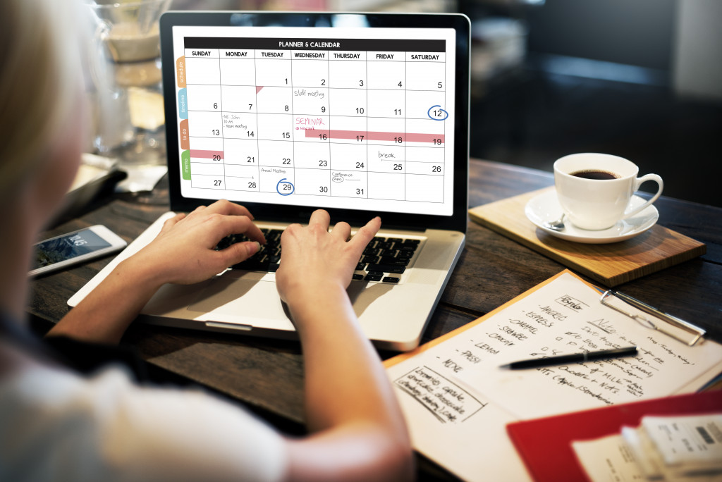 a woman using a laptop to make a calendar of goals