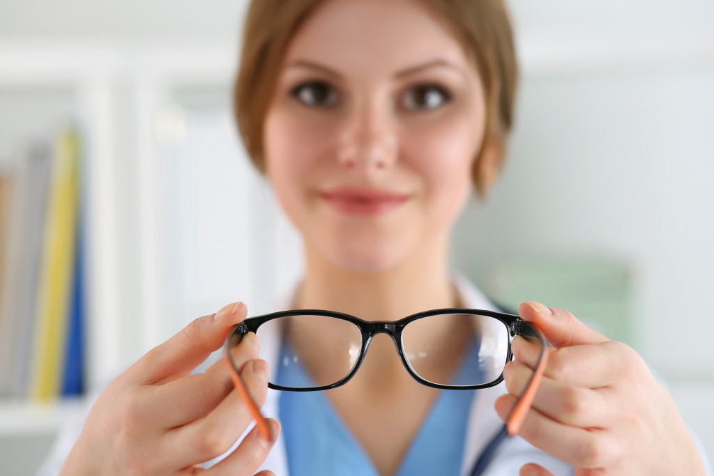 An optometrist handing eyeglasses