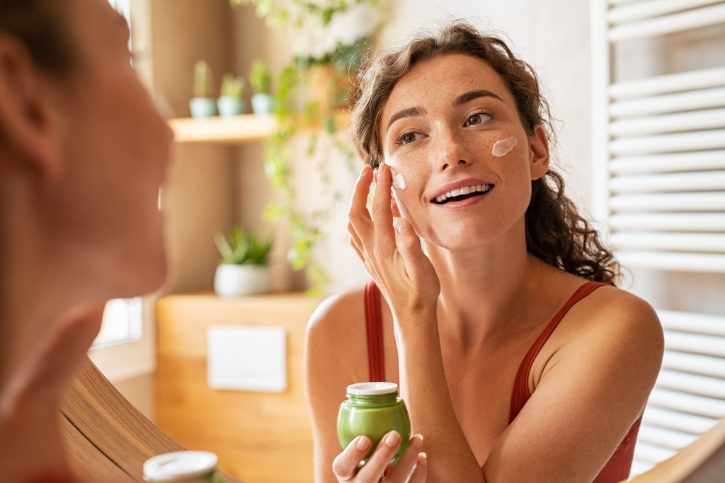 a woman applying skincare product