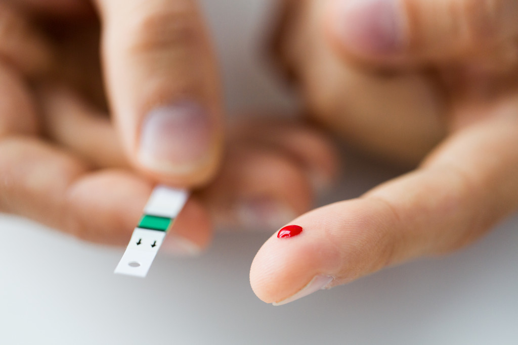 male finger with blood checking for blood sugar