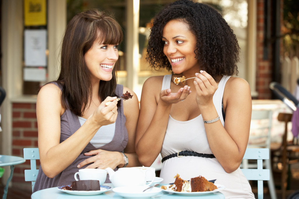 two women eating small portions of desserts