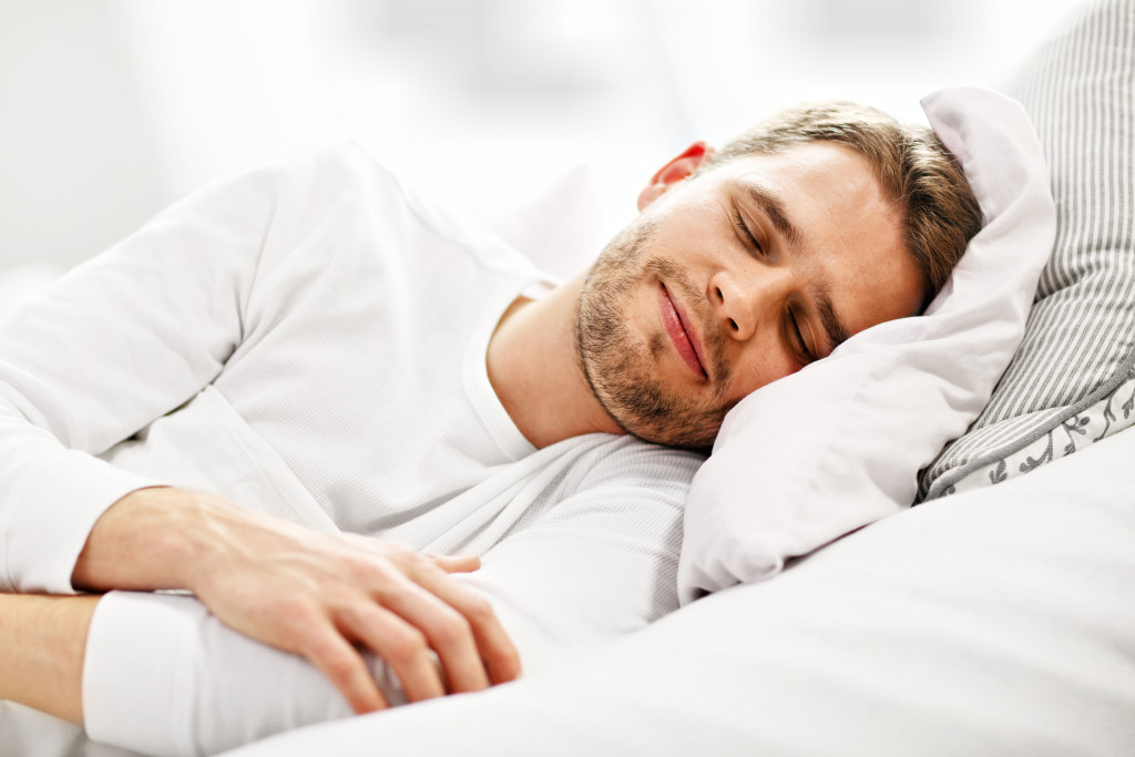 smiling man while sleeping in bed