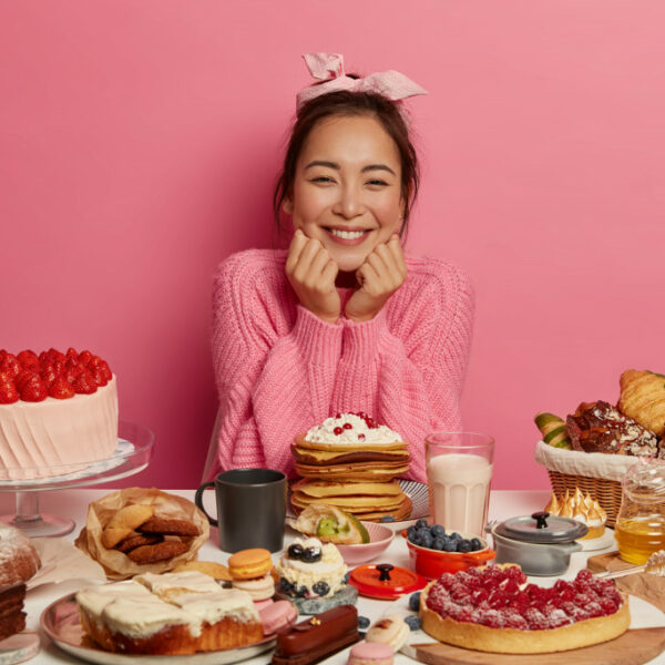 a woman in front of table full of sweet treats