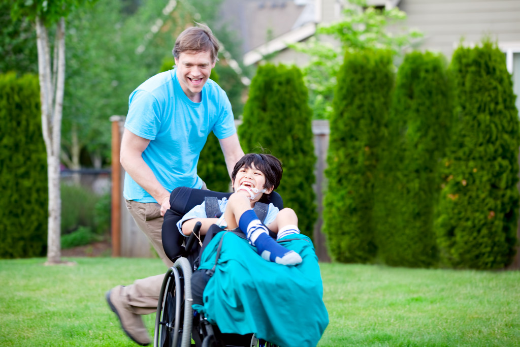 a father pushing his son on the wheelchair