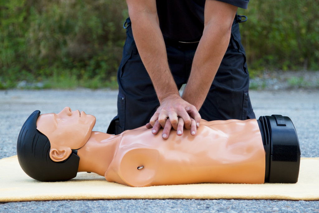 a professional doing chest compressions in a dummy for CPR training