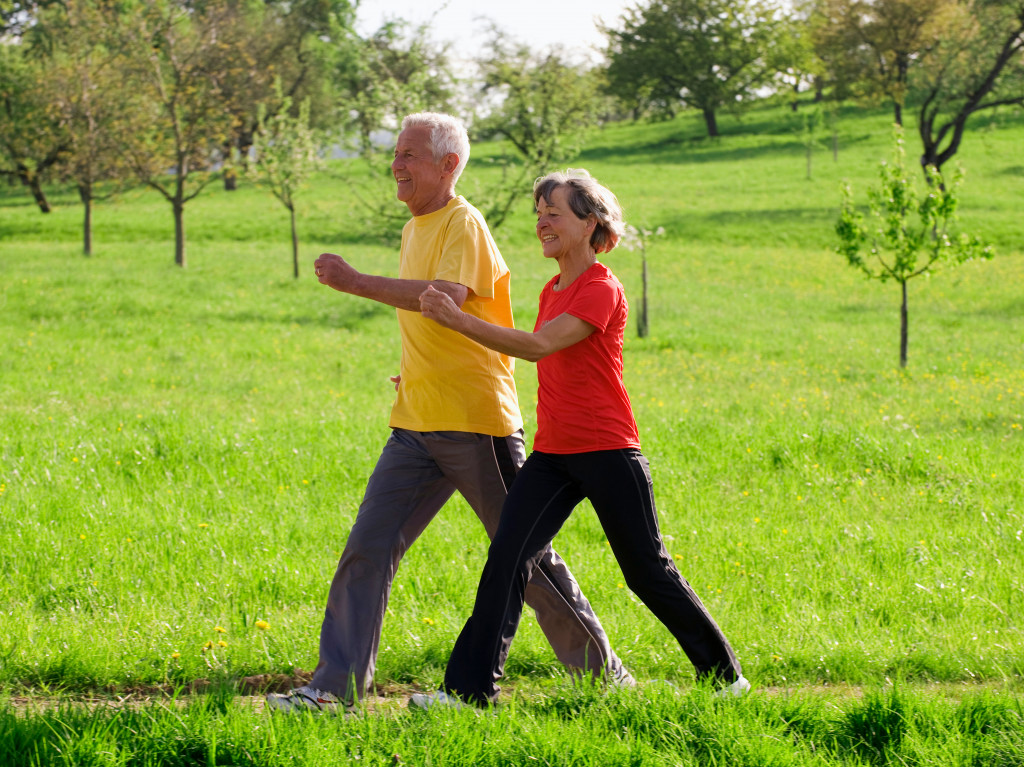 Senior couple brisk walking in a field