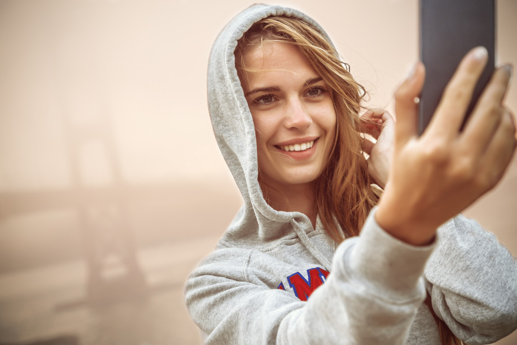 Young woman smiling while taking a selfie.