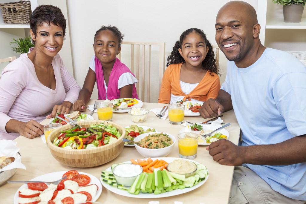 Small family eating a healthy lunch with fruits and vegetables.