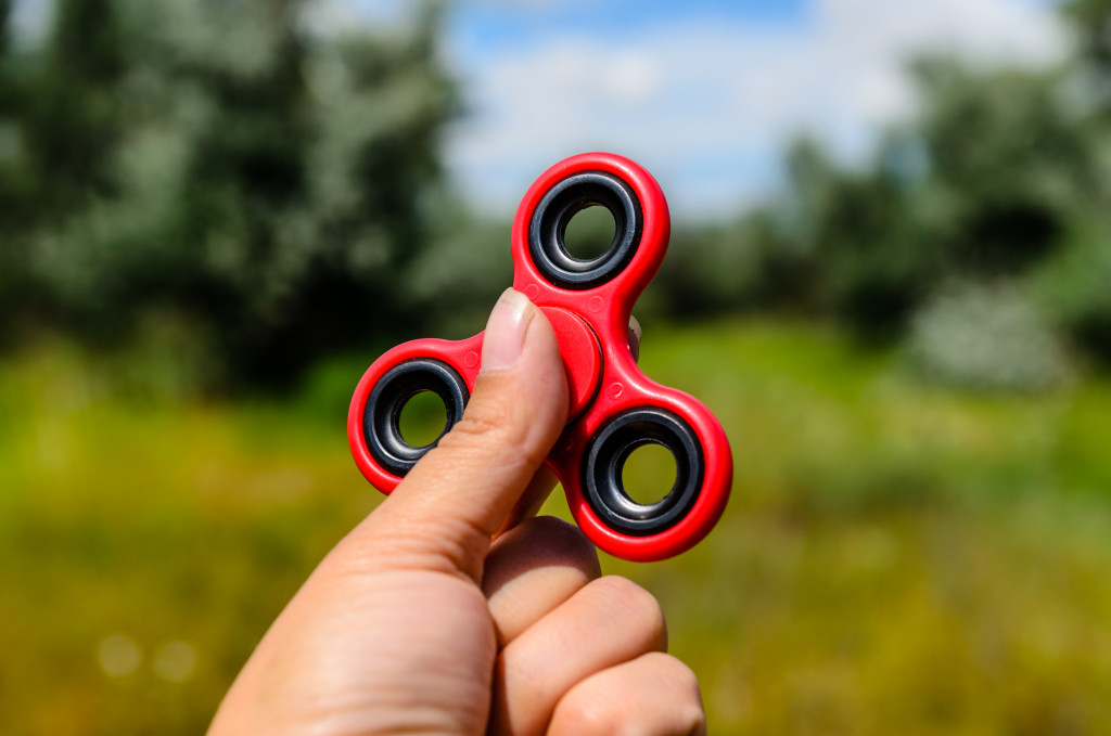 red fidget spinner in an outdoor setting